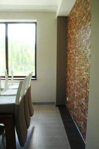 uma sala de jantar com uma parede de tijolos e uma mesa e cadeiras em Cabana Bella Vista em Ranca