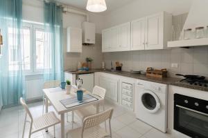 a kitchen with a table and a washing machine at Case da Amare - Alassio Centro in Alassio