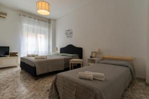 a bedroom with two beds and a television in it at Case da Amare - Alassio Centro in Alassio