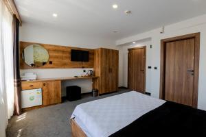 a bedroom with a bed and a desk and a television at Acar Airport Hotel in Arnavutköy
