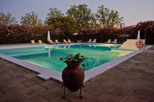 une grande piscine avec un vase de fleurs à côté dans l'établissement SL Hotel Santa Luzia – Elvas, à Elvas