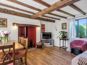 ein Wohnzimmer mit einem Tisch und einem TV in der Unterkunft Pass the Keys Lovely Cottage just outside of Canterbury in Canterbury