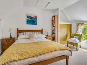 a bedroom with a large bed and a chair at Pass the Keys Lovely Cottage just outside of Canterbury in Canterbury