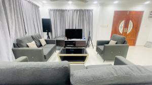a living room with two couches and a tv at Sporting Homestay in Semporna