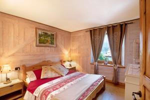 a bedroom with a bed with wooden walls and a window at Maison Grange 4 in Gressan
