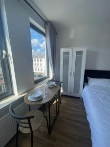 Habitación con mesa, cama y ventana en Cozy and central Apartment Lübeck en Lübeck