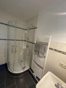 La salle de bains est pourvue d'une douche et d'un lavabo. dans l'établissement Cozy and central Apartment Lübeck, à Lübeck