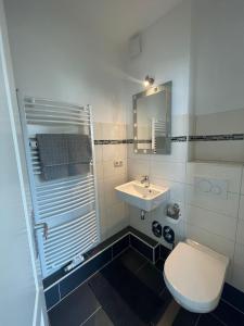 a bathroom with a white toilet and a sink at Cozy and central Apartment Lübeck in Lübeck