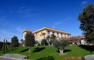 un bâtiment avec une pelouse verte devant lui dans l'établissement Hotel Venko, à Dobrovo