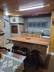 una cocina con una gran isla de madera en una habitación en Chalé Bela Vista, en Gramado