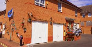 ein Backsteingebäude mit drei weißen Garagentüren darauf in der Unterkunft Marina,Families are welcome in East Cowes