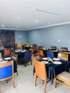 a dining room with tables and chairs with blue walls at Munisa Guest House in Johannesburg