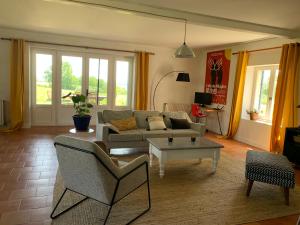 ein Wohnzimmer mit einem Sofa und einem Tisch in der Unterkunft Guest house avec vue sur 2 hectares in La Sauvetat-du-Dropt