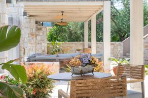 a patio with a table with flowers on it at Villa Teresa Luxury Suites in Limenas