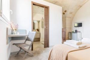 a bedroom with a bed and a desk and a chair at Casale alle Vigne in Nardò