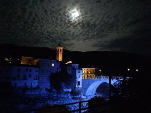 - une vue sur une ville la nuit avec la lune dans l'établissement Apartma MOST, à Kanal