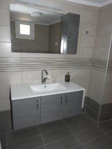 La salle de bains est pourvue d'un lavabo blanc et d'un miroir. dans l'établissement Serene, slow living house, à Orné
