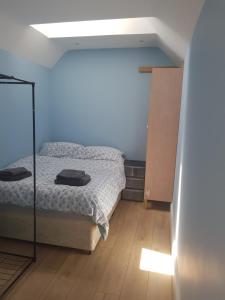 Dormitorio pequeño con cama y espejo en Cosy Studio Luton en Luton