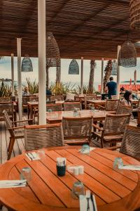 una mesa de madera y sillas en un restaurante en Les Prairies de la Mer en Grimaud