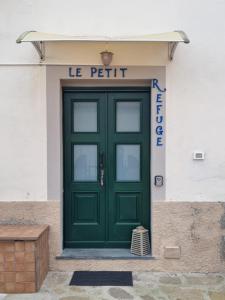 a green door on the side of a building at Le petit refuge in Capraia