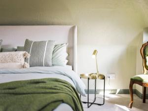 a bedroom with a bed with a green blanket and a chair at The Loft - A Stylish Holiday Property in Weymouth with Sea View and Parking in Weymouth