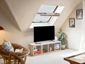 a living room with a flat screen tv in a attic at The Loft - A Stylish Holiday Property in Weymouth with Sea View and Parking in Weymouth