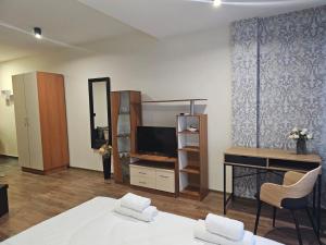 Dormitorio con cama, escritorio y TV en Studio MIRAGE, en Kazanlak