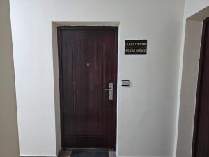 een houten deur in een hal met een bord erop bij Studio MIRAGE in Kazanlik