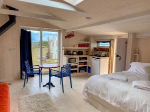 a bedroom with a bed and a table and chairs at The Surf Shack in Camber