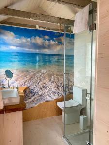 a bathroom with a painting of the ocean at The Surf Shack in Camber