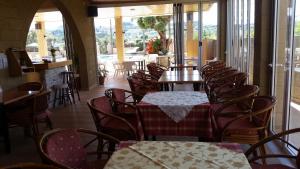 a dining room with tables and chairs and a room with windows at Summer Days in Faliraki