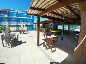 a patio with tables and chairs on a building at Pousada Mirante da Prainha in Arraial do Cabo