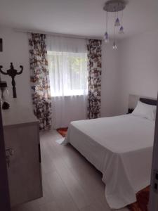 um quarto com uma cama branca e uma janela em Apartment Rezidence em Suceava