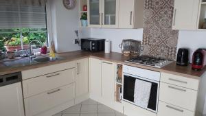 a kitchen with white cabinets and a sink and a stove at Ronyhome in Balatongyörök