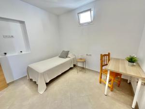 1 dormitorio con cama, mesa y ventana en F&M Familiar, en La Laguna