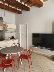 Una cocina con mesa y sillas y un televisor. en Mossotti Street Apartment, en Pisa