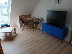 a living room with a tv on a blue dresser at Ferienwohnung kleine Möwe mit E-Bike Verleih in Wilhelmshaven