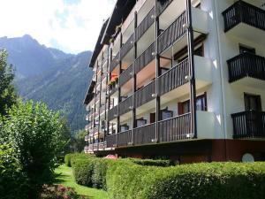 un bâtiment avec des balcons et des buissons à côté d'une montagne dans l'établissement Résidence Les Périades, à Chamonix-Mont-Blanc