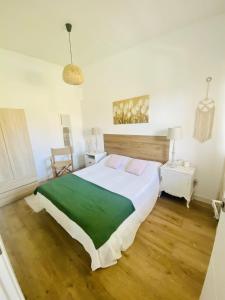 a bedroom with a large white bed and wooden floors at La casuca de Ivan 