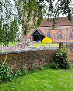 a brick wall in front of a building at STABLE COTTAGE in Cheswardine