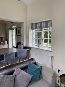 un salon avec un canapé et une cuisine dans l'établissement STABLE COTTAGE, à Cheswardine