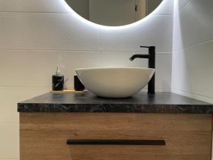 baño con lavabo blanco y espejo en Apartamentos TriBeCa Centro I, en Albacete