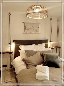 a bedroom with a large bed with white pillows at APPART HOTEL Place des Jolis Rêves in Riom-ès-Montagnes