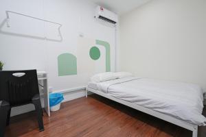 een slaapkamer met een bed, een bureau en een stoel bij Aimelia guest house by G traveler in Petaling Jaya