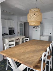 cocina con mesa de madera y electrodomésticos blancos en Villa Chati, en Santander