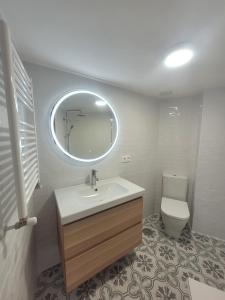 y baño con lavabo, aseo y espejo. en Villa Chati, en Santander