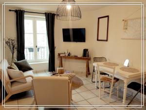a living room with a table and a dining room at APPART HOTEL Place des Jolis Rêves in Riom-ès-Montagnes