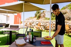 a man standing at a table with a bowl of food at Faro di Punta Fenaio - Caletta Privata in Campese