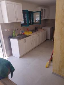 a kitchen with white cabinets and a sink at Vila Sipovac in Budva