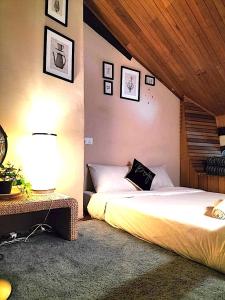 a bedroom with two beds and a table with a lamp at Le Meilleur in George Town